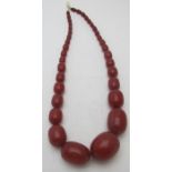 A graduated vintage cherry amber coloured necklace, the largest bead approx 40mm x 30mm.