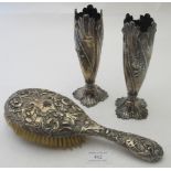 A pair of silver vases with embossed floral decoration, import marks for London 1890, weighted,