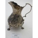 A Victorian silver cream jug embossed with flowers and acanthus leaf double scroll handle, London