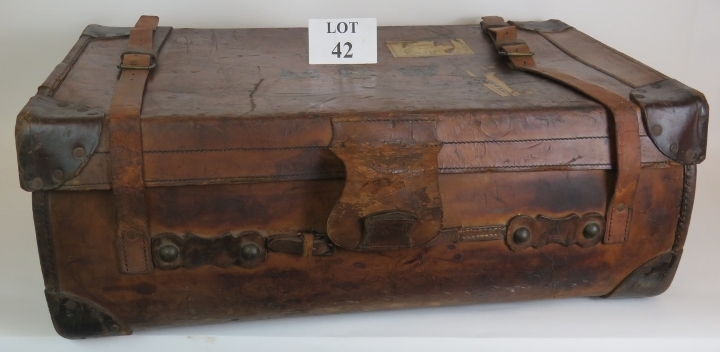 An antique leather travel trunk with wood slatted base and period labels. 82cm x 50cm x 30cm.