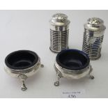 A pair of cylindrical silver peppers with pierced decoration, London 1911, with blue liners (one