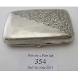 A silver cigarette case with gilded interior and engraved decoration to the front and back,