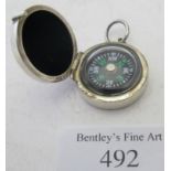 A small white metal cased compass, engraved F T. Condition report: Slight surface wear.