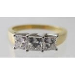 An 18ct white and yellow gold princess cut diamond trilogy ring. Diamonds 1.00cts, colour grade D-E,