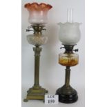 A tall elegant brass Corinthian column based oil lamp with cut glass reservoir and filigree shade
