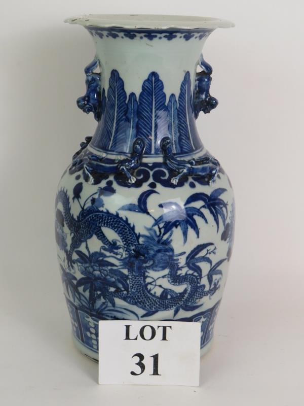 An antique blue and white Chinese porcelain vase decorated with four claw dragons and with applied