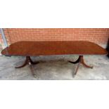 An early to mid 20th century mahogany D end twin pedestal dining table with one extra leaf.