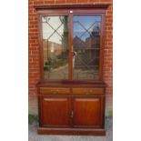 An Edwardian mahogany tall bookcase with dentil cornice over astral glazed doors opening onto