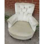 A Victorian low bedroom armchair upholstered in a cream buttoned velvet, raised on tapering turned