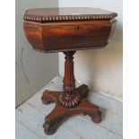 A Regency rosewood teapoy with gadrooned edging, raised on a baluster turned fluted column and