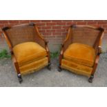 A pair of late Victorian pale mahogany bergere tub chairs with loose seat cushions upholstered in