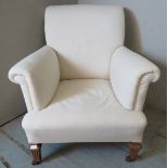 A late Victorian club armchair with scrolled arms & backrest upholstered in calico, raised on
