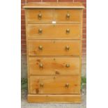 A tall pine chest of two over three long drawers with brass drop ring handles, raised on a plinth
