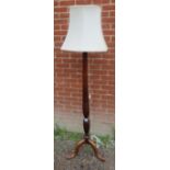 An antique mahogany standard lamp with fluted column carved with wheatsheaf details, raised on an