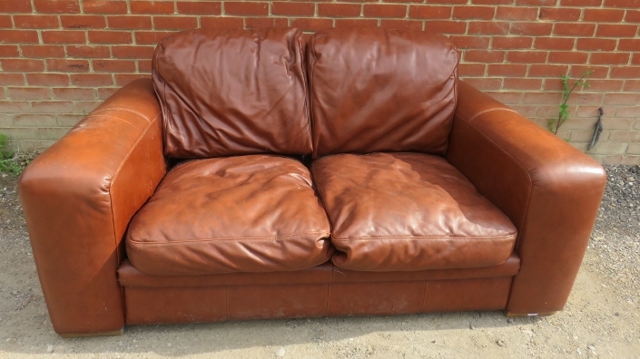 A contemporary two seater sofa upholstered in brown leather. 82cm high x 180cm wide x 102cm deep (