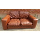 A contemporary two seater sofa upholstered in brown leather. 82cm high x 180cm wide x 102cm deep (