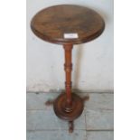 A Victorian mahogany torchere with a baluster turned column & dished circular base with outsplayed