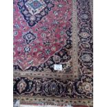 A mid 20th Century Persian carpet with central Medalion on red ground and bordered in blue. 200cm