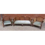 A Victorian mahogany three piece suite with bergere back and side panels and ornately carved swan