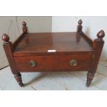 A Regency mahogany Canterbury base with turned finials, raised on tapering supports with brass