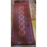 A 20th Century Persian rug on claret ground. 140cm x 52cm. Condition report: Good even colour and