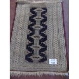 A small Persian rug on cream ground with central repeat pattern in blue. 114cm x 84cm. Condition