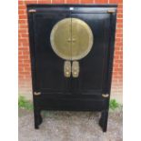 A 20th century Chinese black lacquered elm marriage cabinet, the double doors opening to