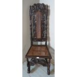 A Carolean oak hall chair ornately carved with Flemish scrolls & eagle motifs, surmounted by a