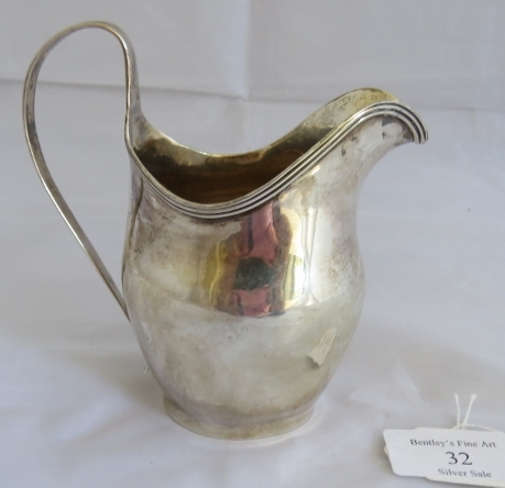 A Georgian silver helmet shaped cream jug with reeded pattern to handle and rim. London 1803, makers