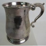 A Georgian silver tankard, (marks rubbed, either London 1736 or 1776), having a baluster body an