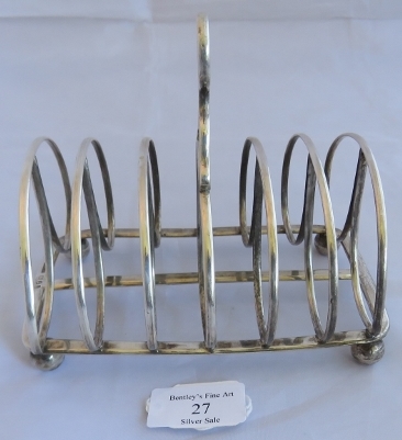 A large Georgian silver toast rack on ball feet, Sheffield 1824, maker John and Thomas Settle.