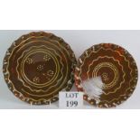 Two contemporary slipware chargers both with concentric line and dot decoration and crimped rims.