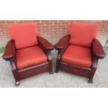 A pair of Art Deco club armchairs upholstered in distressed brown leather with seat cushions