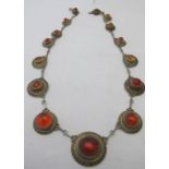 A fine amber mounted white metal necklace consisting of fifteen graduated amber discs joined