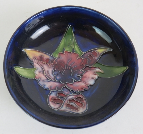 A small Moorcroft pottery dish with orchid decoration on a dark blue ground. Incised Moorcroft - Image 2 of 4