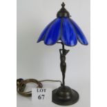 A Tiffany style table lamp with bronze nude under a blue glass petal shaped shade. Overall height