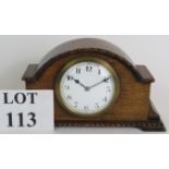 An early 20th Century oak cased French mantel clock with enamel dial. Height 13.5cm. Condition