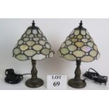 A pair of Contemporary Tiffany style bedside lamps on bronze foliate bases and with pearl stained