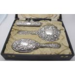 A three piece silver backed dressing table set comprising of hand mirror, hair brush & clothes