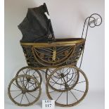A Victorian style doll's pram with rattan cane basket. Steel frame, porcelain handles and wood
