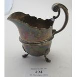 A silver cream jug on pad feet with double scroll handle & thumb piece, London 1892, approx weight