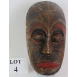 A hand carved Maori Koruru mask with carved tattoo design and polychrome decoration, probably late
