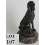 A contemporary bronze figure of a sitting bloodhound dog mounted on a red marble base, signed PJ