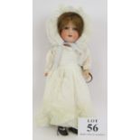 An Armand Marseille bisque headed doll in white lace dress and cap with composite jointed limbs