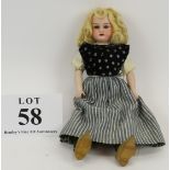 An Armand Marseille bisque headed doll in Dutch dress and clogs with porcelain arms and padded