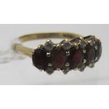 A 9ct yellow gold ring set with five oval shaped garnets & eight small white stones, size P,