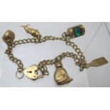 A 9ct gold link charm bracelet with four 9ct gold charms, an unmarked reticulated fish with coral