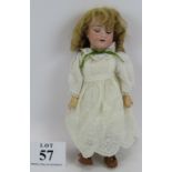 An Armand Marseille bisque headed doll in white broderie anglaise dress with composite jointed limbs