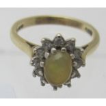 A 9ct yellow gold opal & diamond ring, opal approx 7mm x 5mm, surrounded by twelve small diamonds,