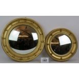 A large gilt wood convex mirror with wood and stucco frame plus a similar smaller metal framed